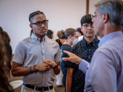 student speaking with faculty member