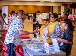 students at a table speaking with a rep at the HSCI College Fair