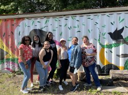 Group of participants from the Montclair’s Urban Teacher Residency and Newark Teacher Project pose before a mural
