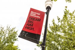 Printed banner on campus reading "Dream Big. Aim High."