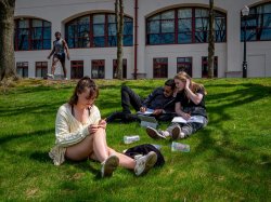 Students sitting on grass on campus