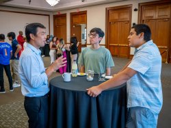 Professor Jonas Zhang talks to students around a table