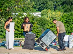 Three people moving large boxes