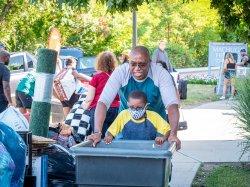 parent pushing a cart with a young child