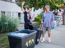 student poses with their parent and cart