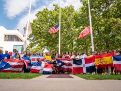 attendees of the flag raising pose with flags on campus