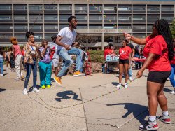 Student doing double-dutch jump rope in the quad in front of Blanton Hall