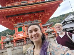 Two students pose for a selfie in front of a pagoda