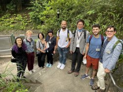 Professor Molina with Professor Munakata and students pose on a staircase