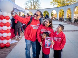 Family of four wearing Montclair State hoodies poses for selfie