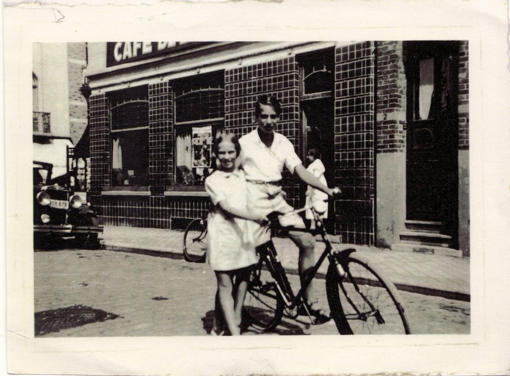 black and white photo of man on bycicle with young girl