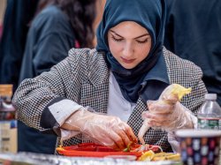 Woman wearing hijab focuses on making Kimchi