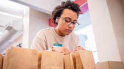 A student looks into paper bags.