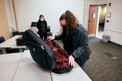 Female student opens musical instrument case.