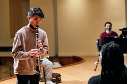 A Male student plays the clarinet.