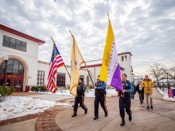 Three flags are carried by police officers in the procession celebrating Women’s History Month.