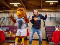 College mascot dances with a student.