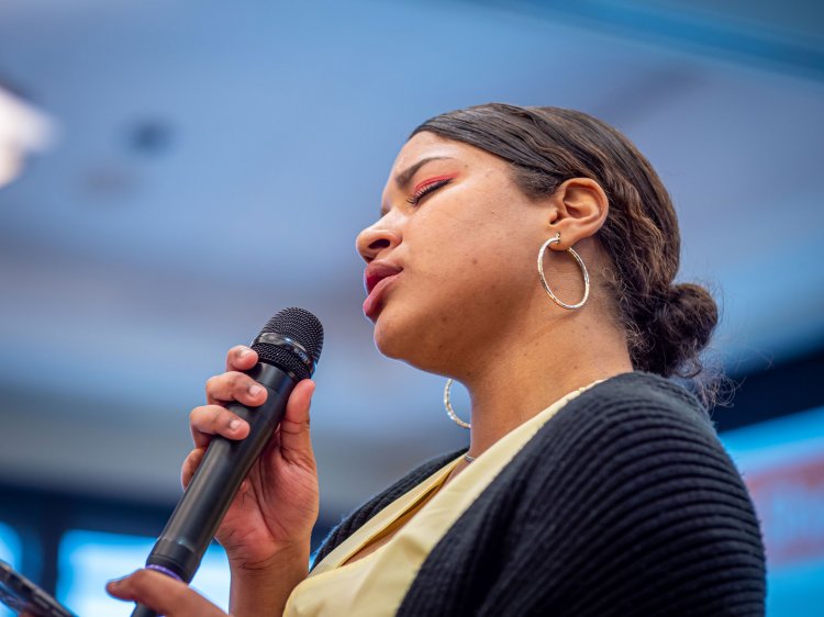 A female student sings into a microphone.
