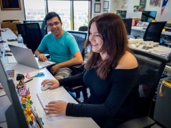 Male student and female student type on computers.