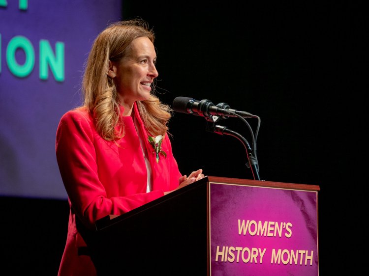 Woman speaks at a podium.
