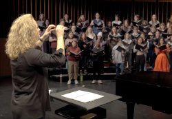 Woman conducts a choir.