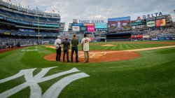 four men stand behind home plate in Yankees stadium