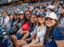 Eight women eight smile in the spectator stands.