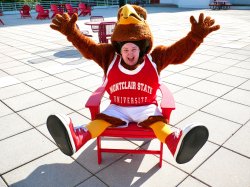 A student in a Red Hawk costume sits in a chair, exposing their face.