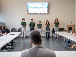 A group of five students make a presentation to an audience.