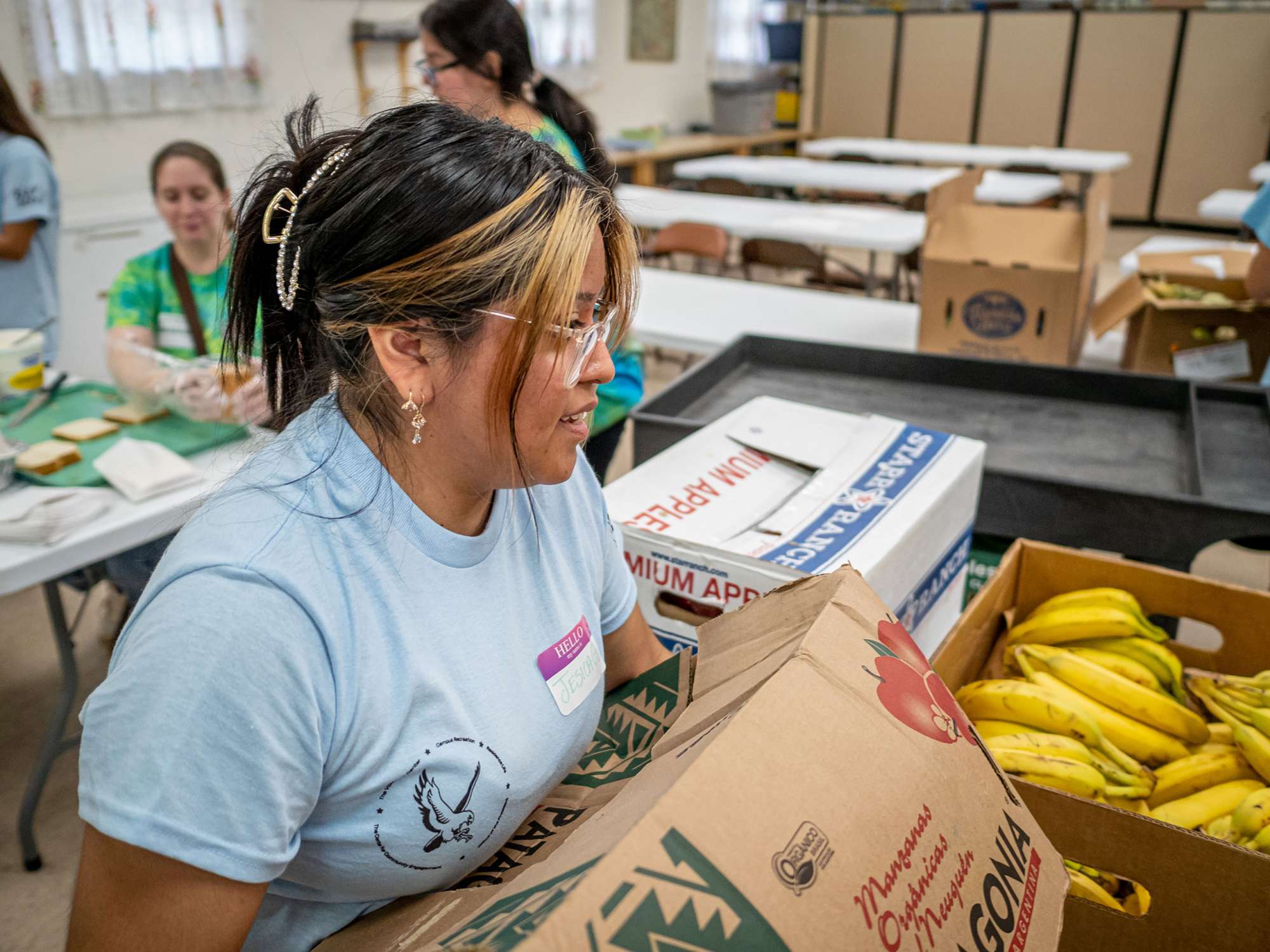 A student carries a box of fruit.