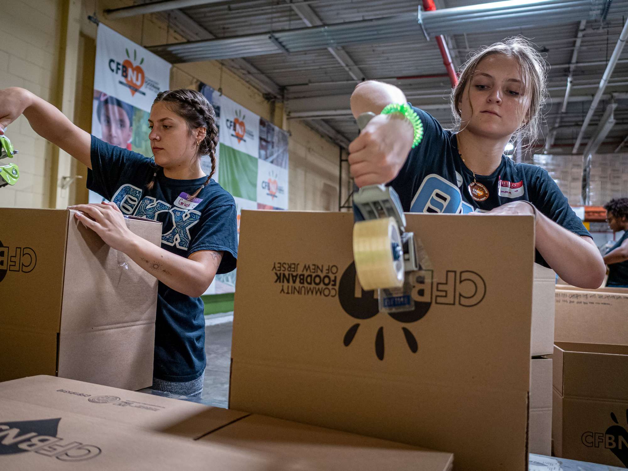 Two students tape boxes.
