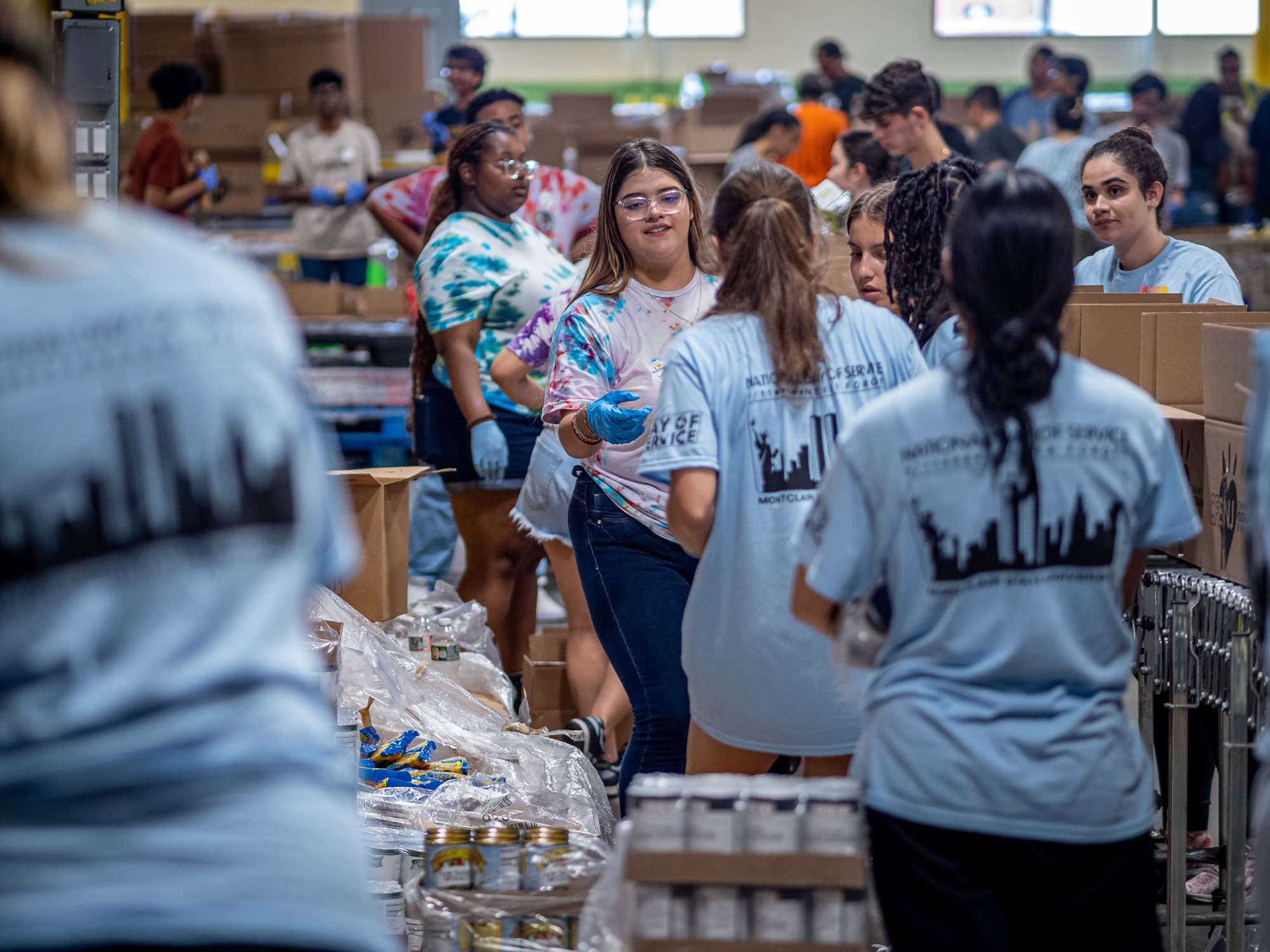 A large group of students work in a warehouse.