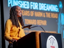 Bettina L. Love smiles as she speaks at a podium.