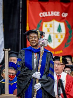 Professor Sandra Adams holding the university scepter
