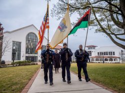 Officers with a US Flag, a NJ state flag, and the Black Liberation flag lead a procession across campus.