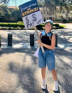 Madison with a "SAG-AFTRA on Strike" picket sign.