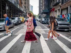 Students walk across a street in New York City.