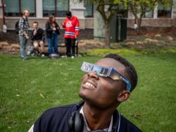 A student looks up wearing his solar eclipse glasses.
