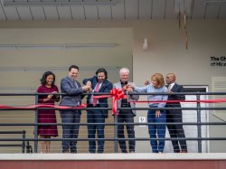 Six people cut the ribbon for The charles J. Muth Museum of Hinchliffe Stadium