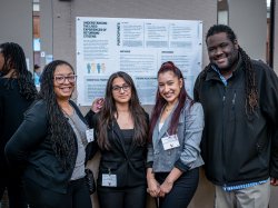 Students pose in front of their research poster with Associate Justice Studies Professor Jason Williams.