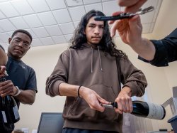 Godek uncorks a bottle of wine. (Photo by University Photographer Mike Peters)