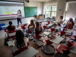 Associate Professor Lauren Covey stands at a whiteboard while teaching an Introduction to Cognitive Science class.