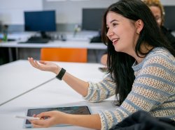 Maura Mayfield gestures during an animation class, holding a stylus and an iPad as she works.