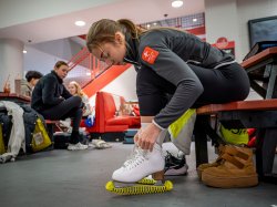 Seated in the lobby of the ice arena, Olga Mikutina ties the laces to her skates.