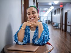 Cookie Howard sits at a table in a hallway in Susan A. Cole Hall.