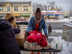 A Montclair student places red blankets on a table.