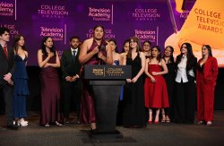 Onstage at the College Television Awards, Dani Mazariegos stands at a podium labeled “Television Academy Foundation College Television Awards,” speaking into a microphone while holding an award, surrounded by Montclair co-reporters dressed in formal evening wear against a purple awards‑show backdrop.