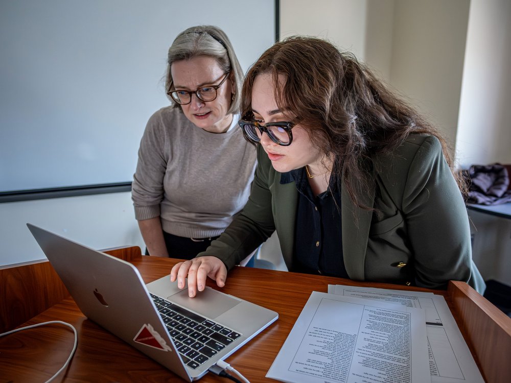 na Barahona and Religion Professor Julia Berger review a lesson plan on a laptop.