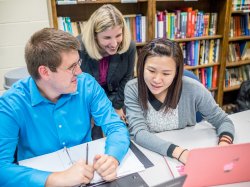 Two students in discussion with instructor