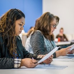 Nursing students in class reading papers.